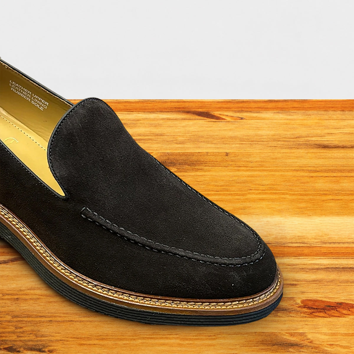 Chocolate Brown Venetian loafer with a rubber sole positioned on a wooden surface.