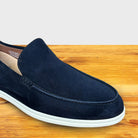 Navy Blue suede loafer shoe on a wooden surface