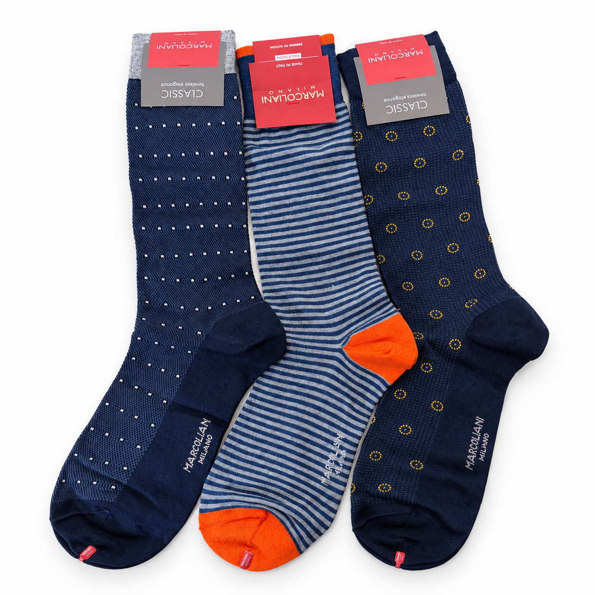 Three pairs of Marcoliani dress socks: navy with white dots, navy and gray stripes with orange heels and toes, and navy with yellow circular patterns.