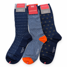 Three pairs of Marcoliani dress socks: navy with white dots, navy and gray stripes with orange heels and toes, and navy with yellow circular patterns.