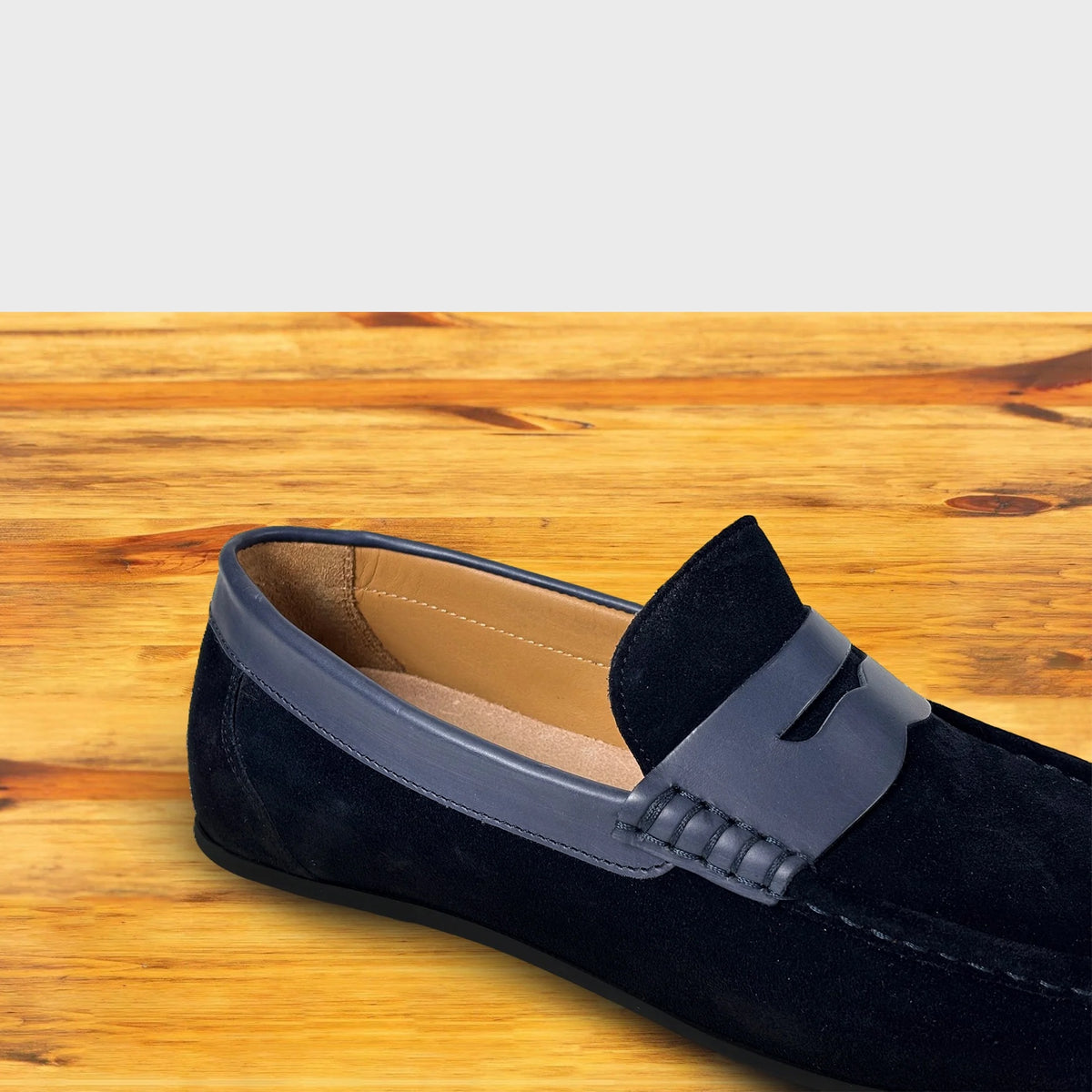 Navy Blue loafer shoe with strap on a wooden surface