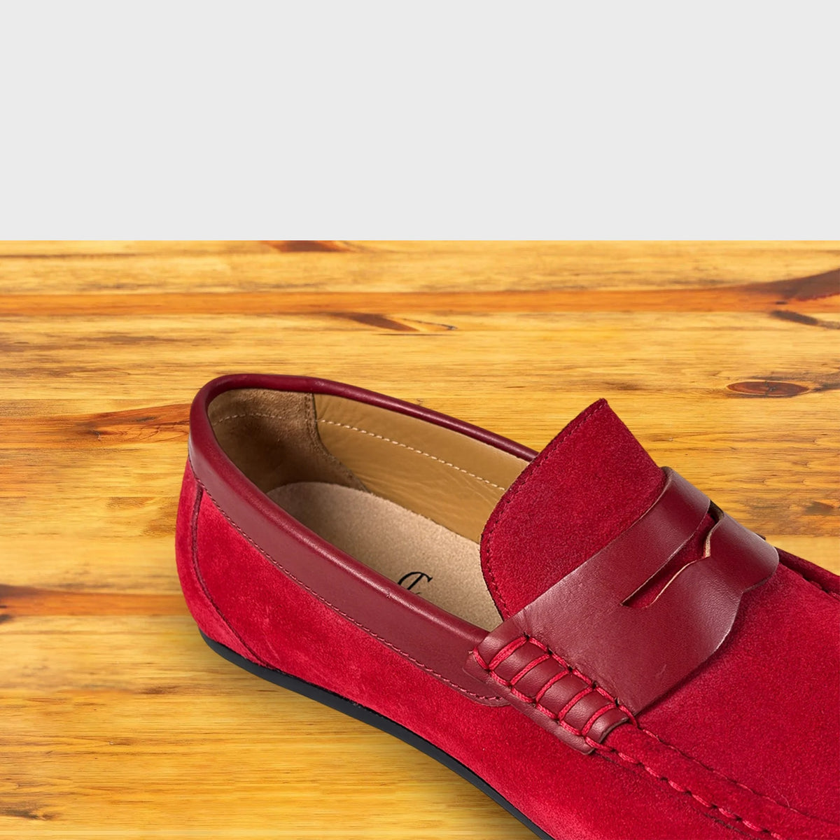 Red loafer shoe on a wooden surface