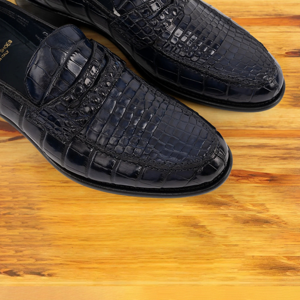 A Pair of Blue leather loafer on a wooden surface