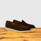 A Pair of Brick suede loafer shoes, displayed on a wooden surface.