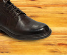 Dark Brown leather dress shoe on a wooden surface