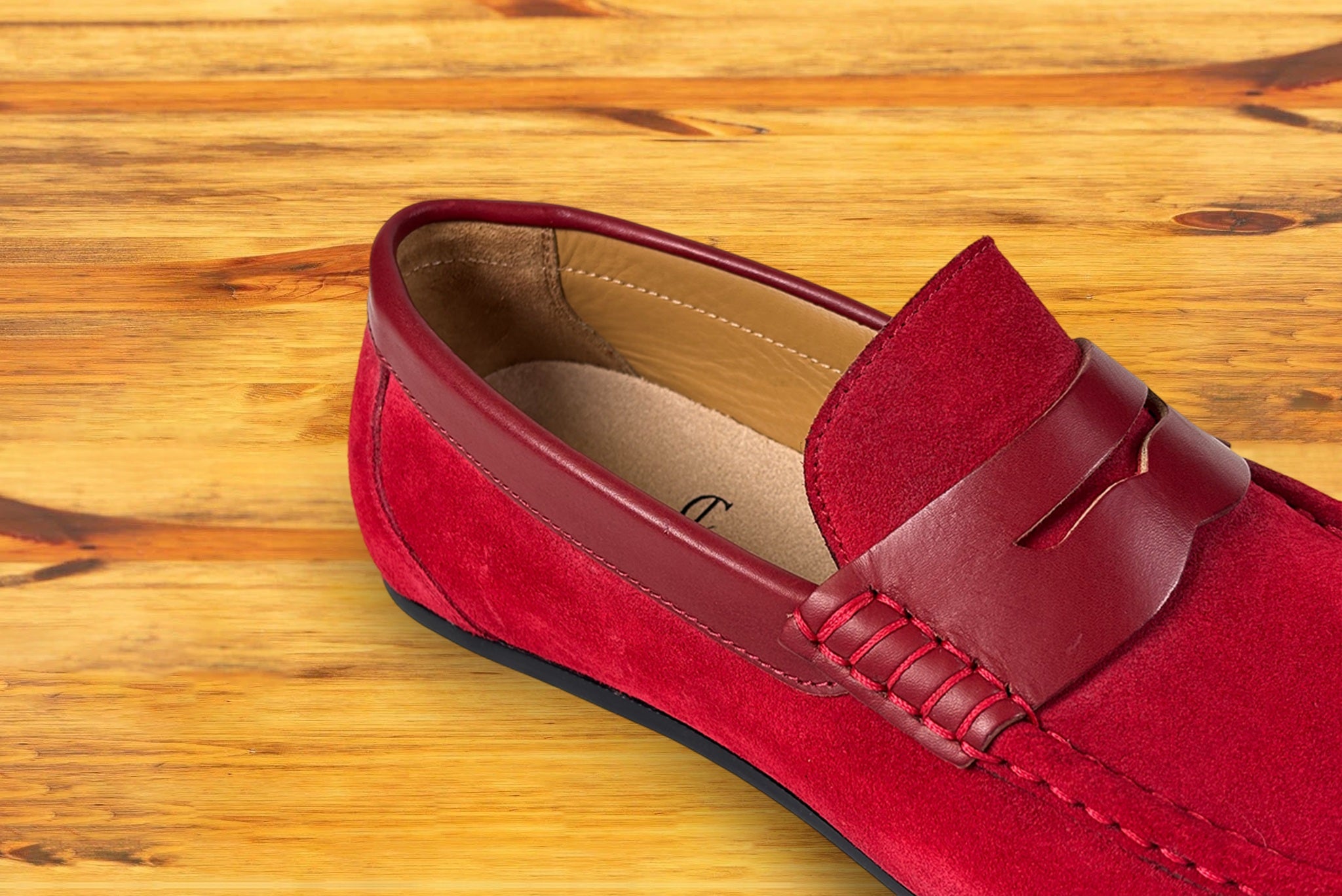Red loafer shoe on a wooden surface
