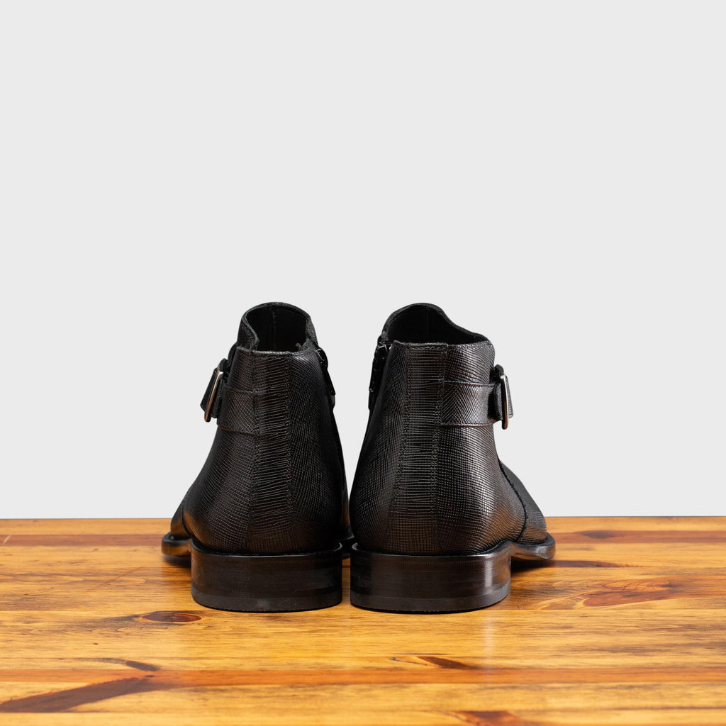 Back profile of the 1221 Calzoleria Toscana Saffiano LeatherBlack  Ankle Zip Boot on top of a wooden table