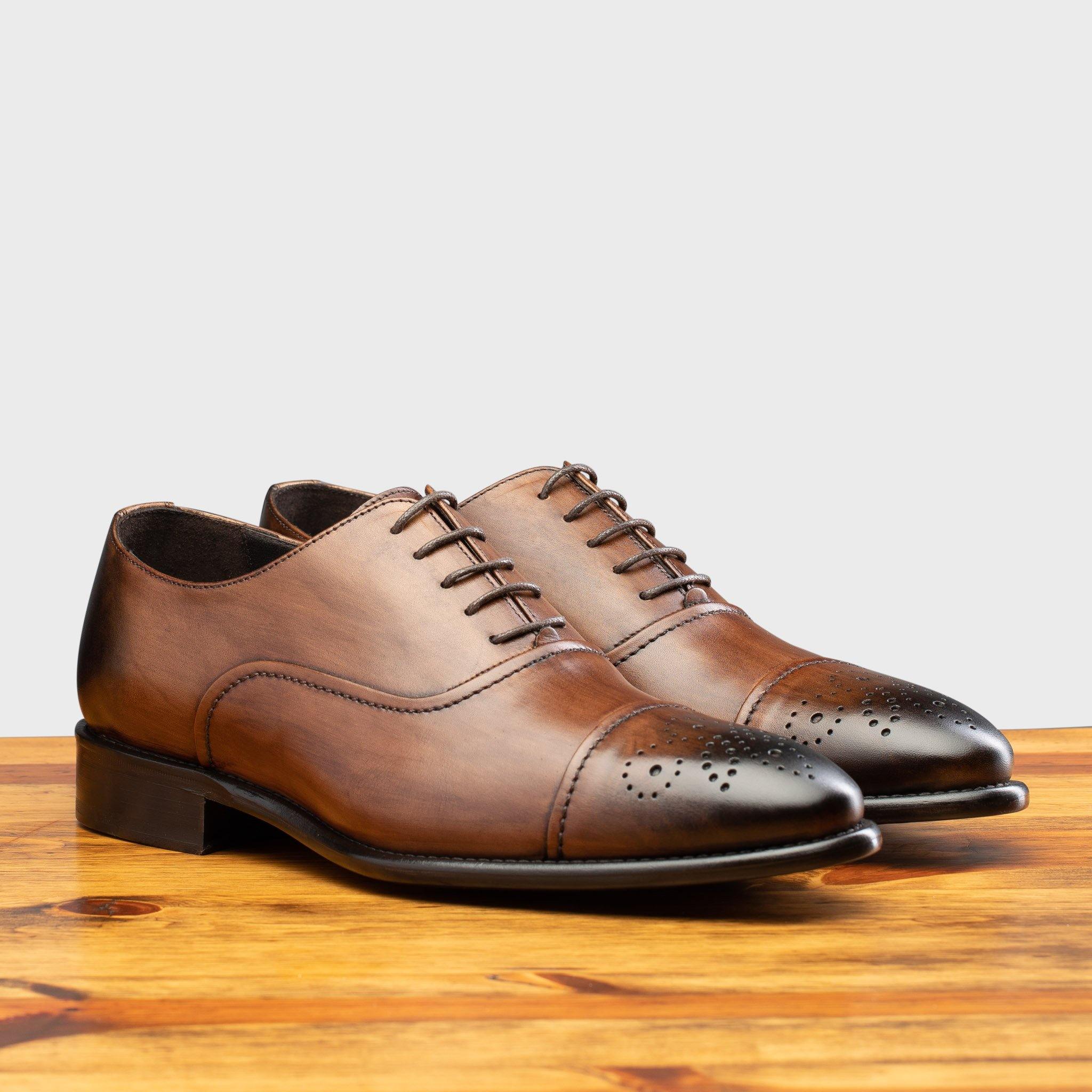Pair of the 2361 Calzoleria Toscana Brown Cayenne Calf Cap-Toe on top of a wooden table