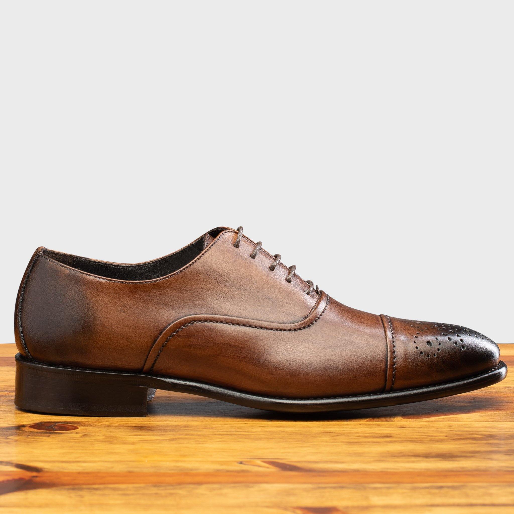 Side profile of the 2361 Calzoleria Toscana Brown Cayenne Calf Cap-Toe on a wooden table