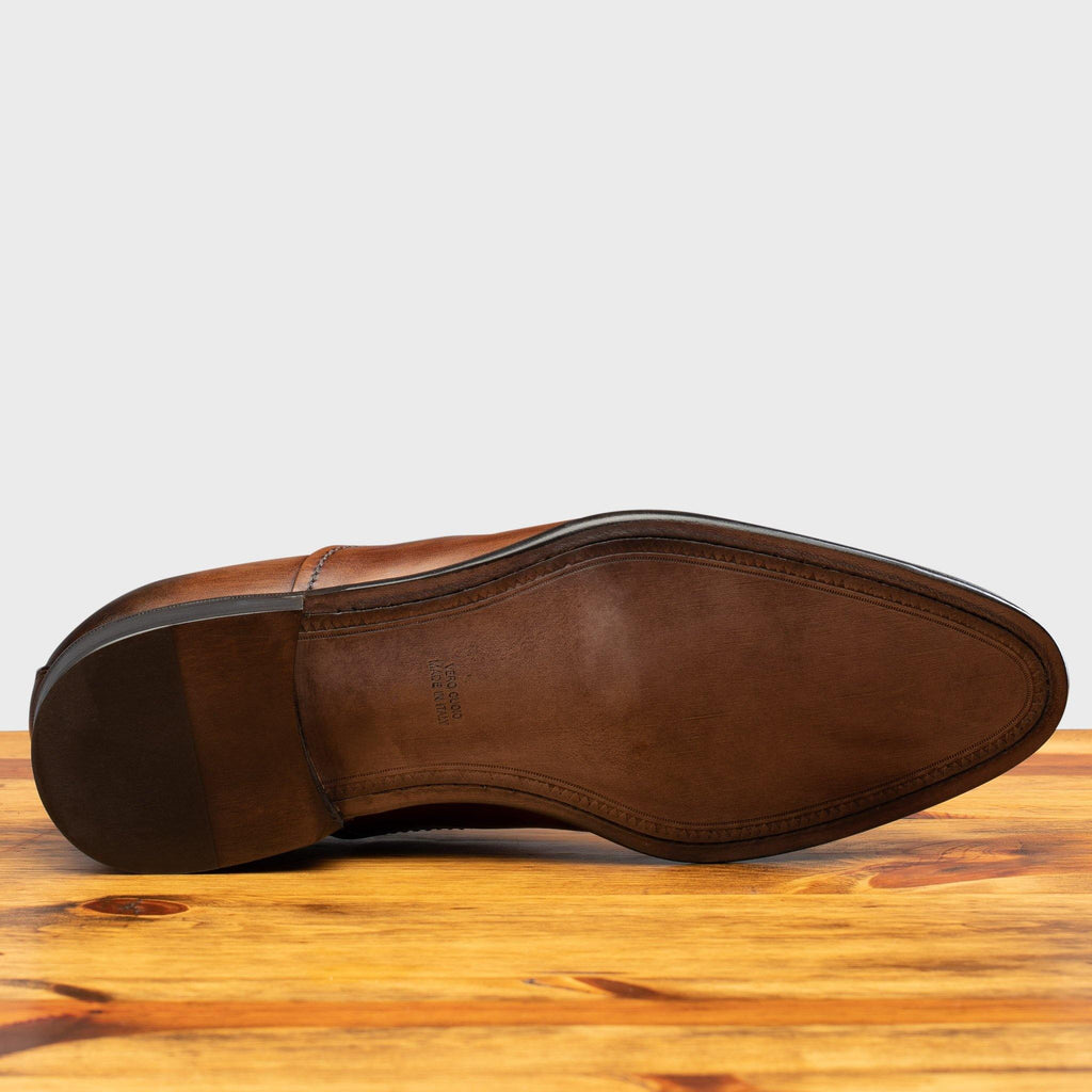 Full leather outsole of the 2361 Calzoleria Toscana Brown Cayenne Calf Cap-Toe on top of a wooden table