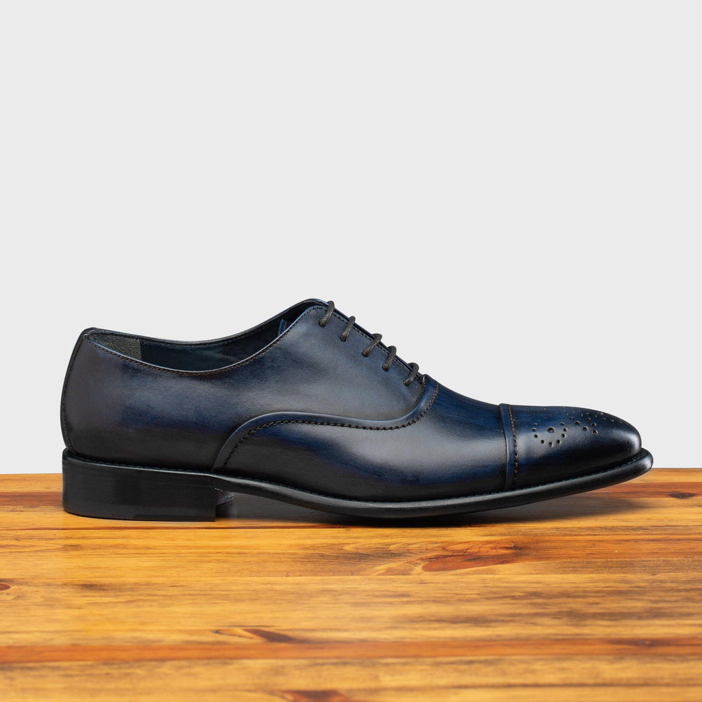 Side profile of the 2361 Calzoleria Toscana Blue Cayenne Calf Cap-Toe on top of a wooden table