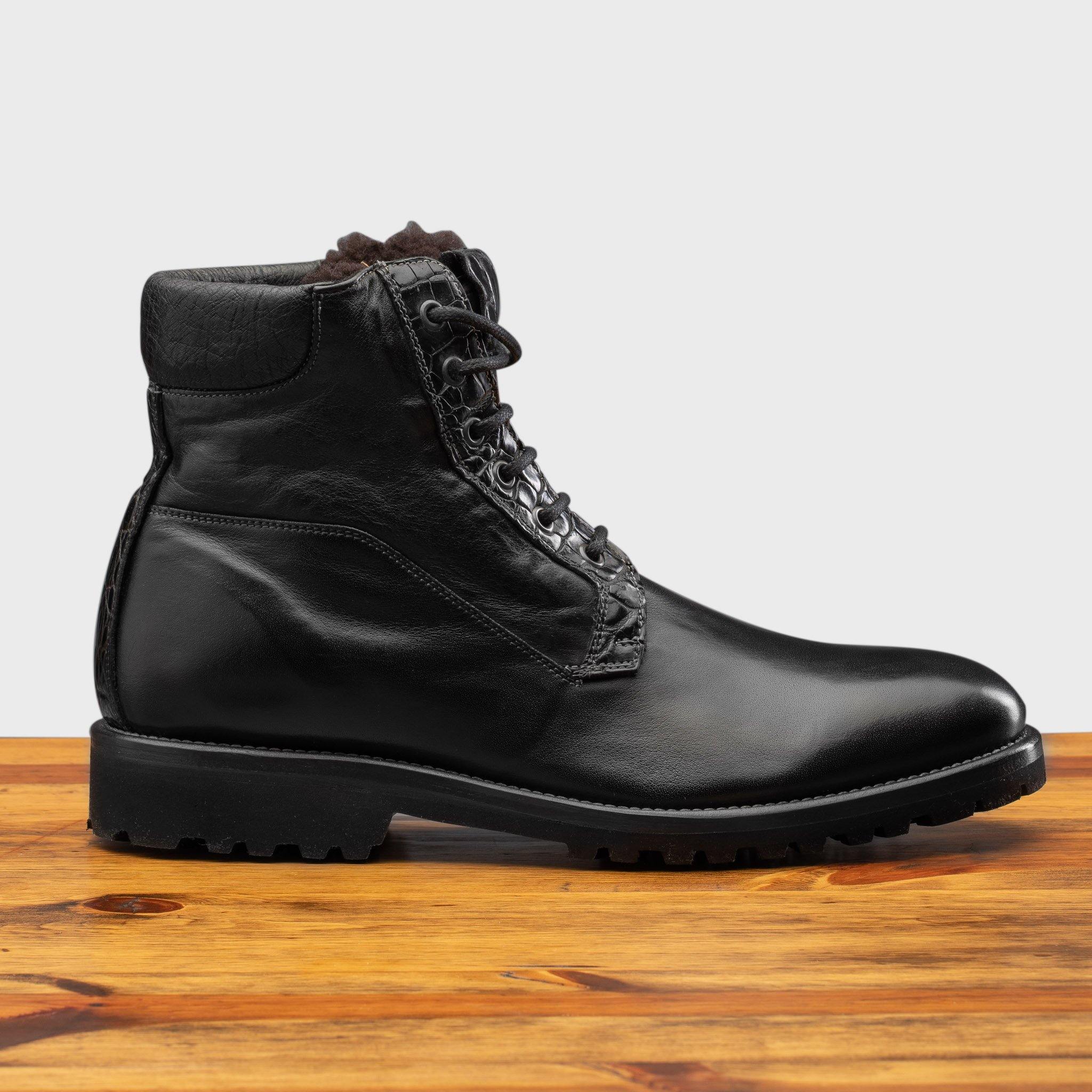 Side profile of the 3236 Calzoleria Toscana Black Shearling Boot on top of a wooden table