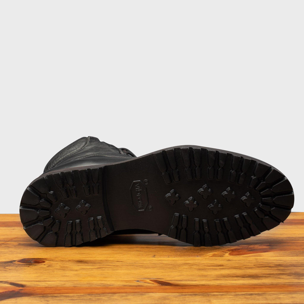 Full Rubber Vibram Outsole of the 3236 Calzoleria Toscana Black Shearling Boot on top of a wooden table