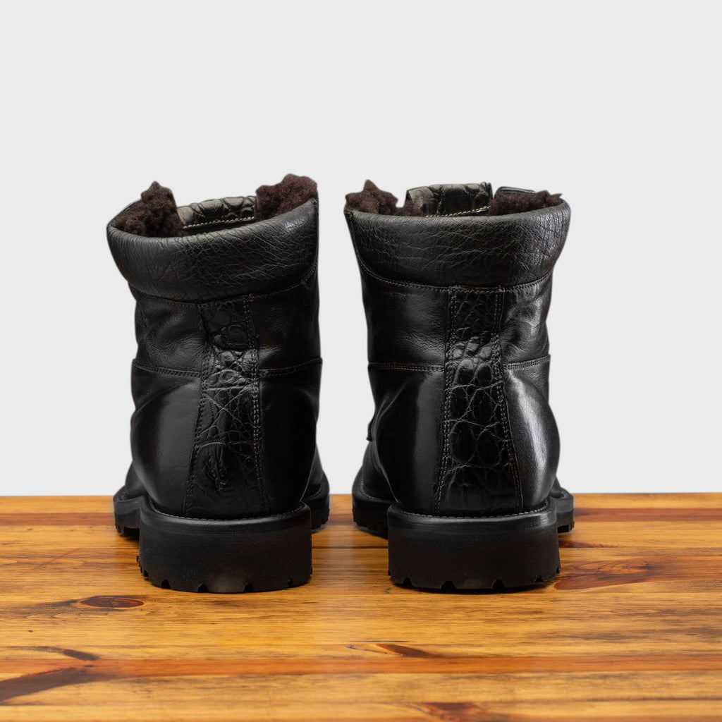 Back profile of the 3236 Calzoleria Toscana Black Shearling Boot on top of a wooden table