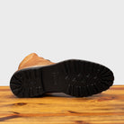 Full Rubber Vibram Outsole of the 3236 Calzoleria Toscana Brick Shearling Boot on top of a wooden table