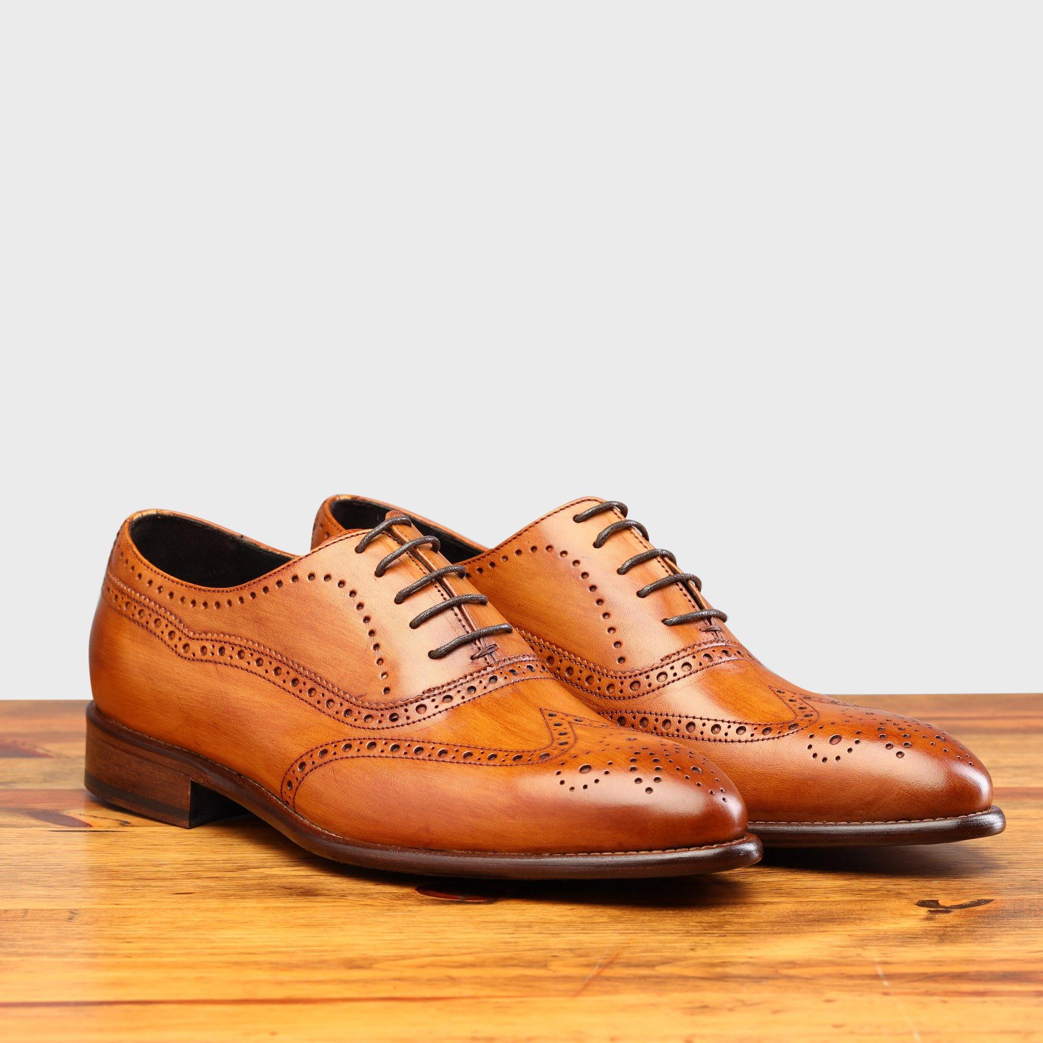 Pair of H742 Calzoleria Toscana Dark Caramel Balmoral Lace-up on top of a wooden table