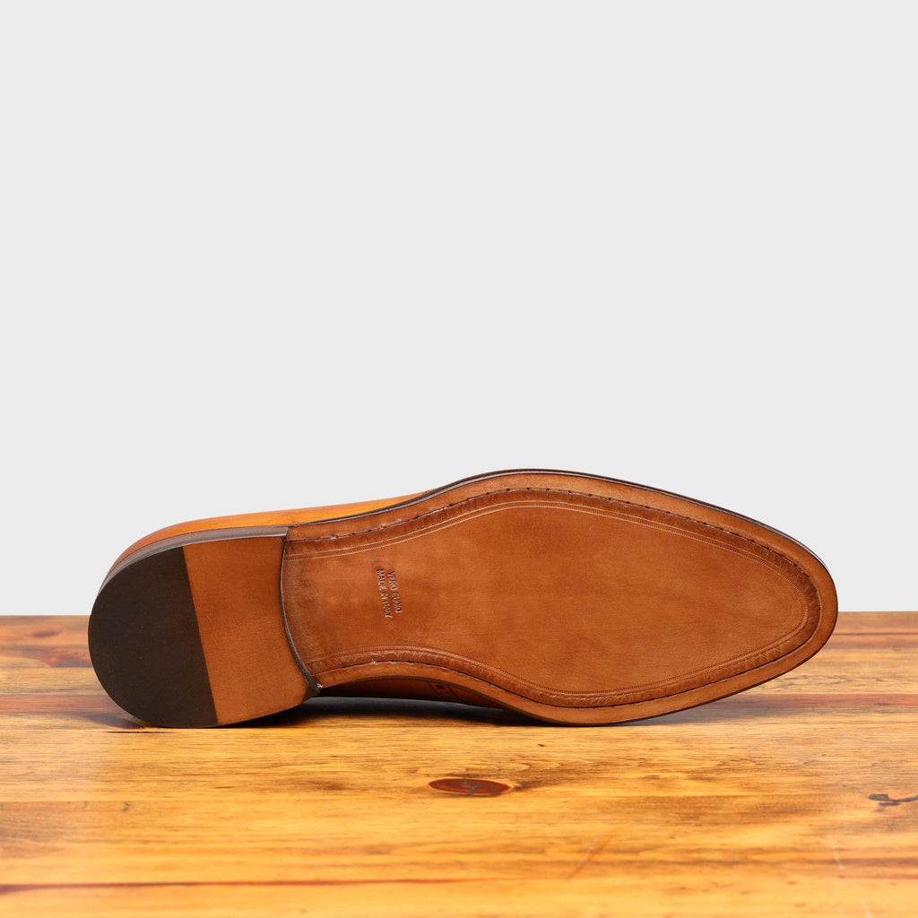 Full leather outsole of H742 Calzoleria Toscana Dark Caramel Balmoral Lace-up on top of a wooden table