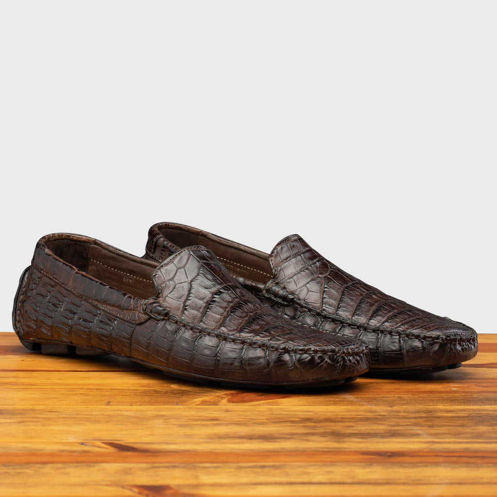 Pair of 4551 Calzoleria Toscana Dark Brown Crocodile Dip-Dyed Driver on top of a wooden table