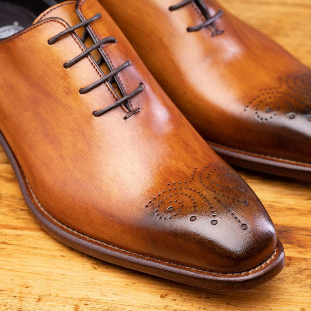 Up Close photo showing the vamp, 4 eyelet and medallion toe of 4633 Calzoleria Toscana Dark Caramel Cayenne Calf Wholecut Balmoral on top of a wooden table