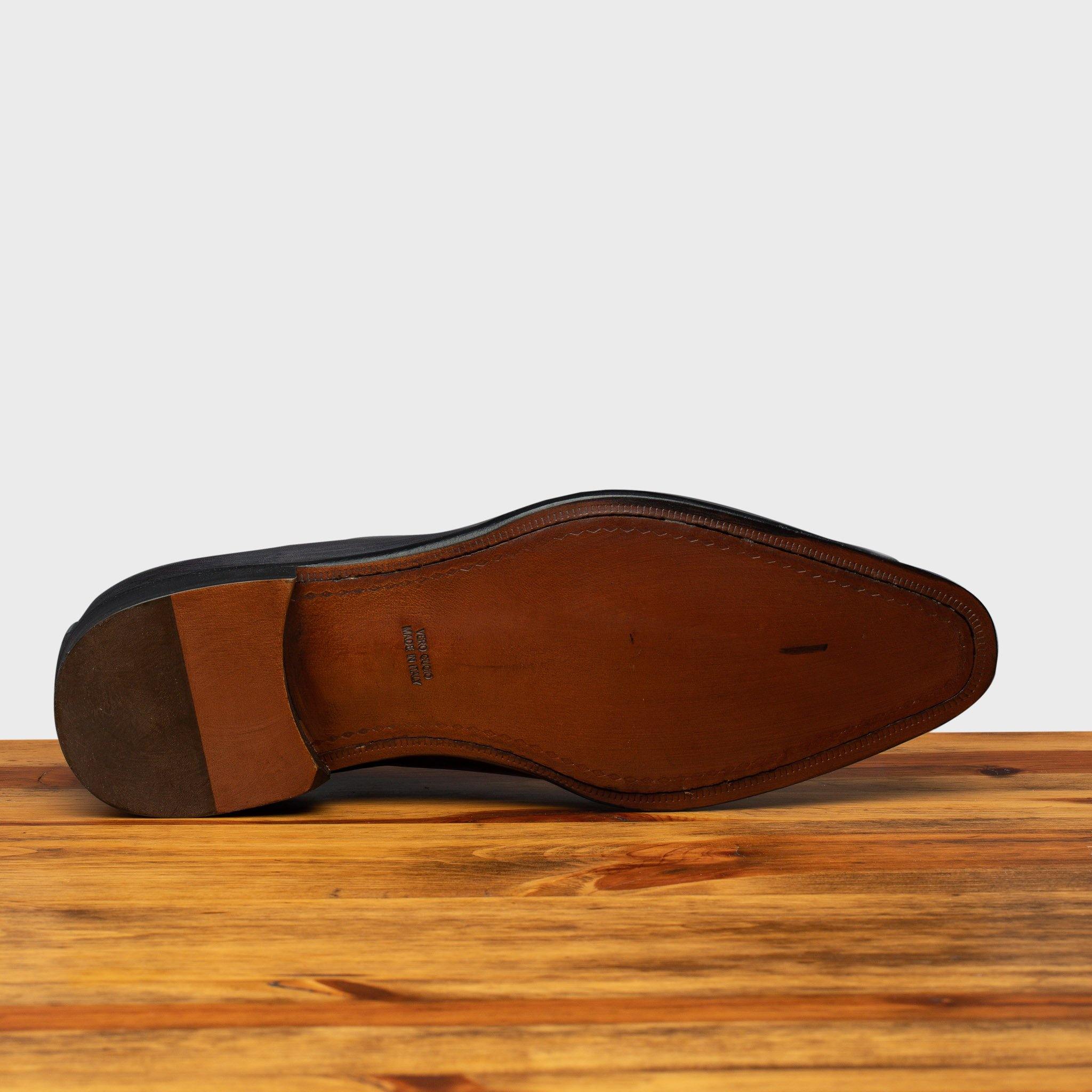 Full leather outsole of 4633 Calzoleria Toscana Grey Cayenne Calf Wholecut Balmoral on top of a wooden table