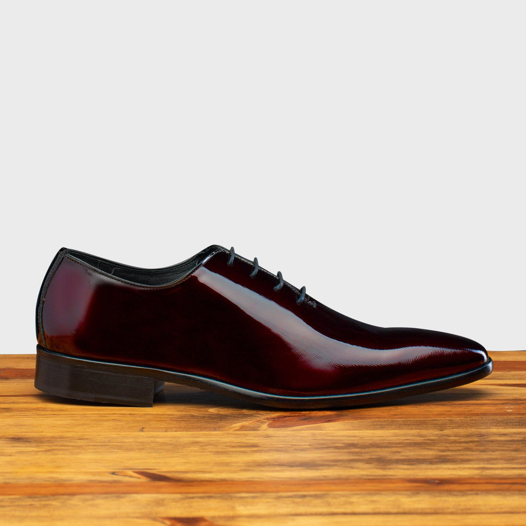 Side profile of the 4870 Calzoleria Toscana Burgundy David Wholecut on top of a wooden table