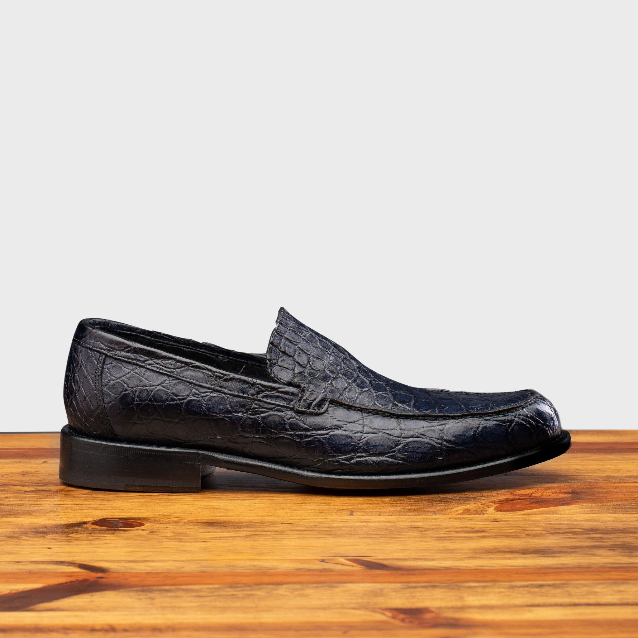 Side profile of 5034 Calzoleria Toscana Ocean Blue Crocodile Slip-On on top of a wooden table