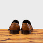 Back Side of Mahogany leather loafer on a wooden surface with a light gray background
