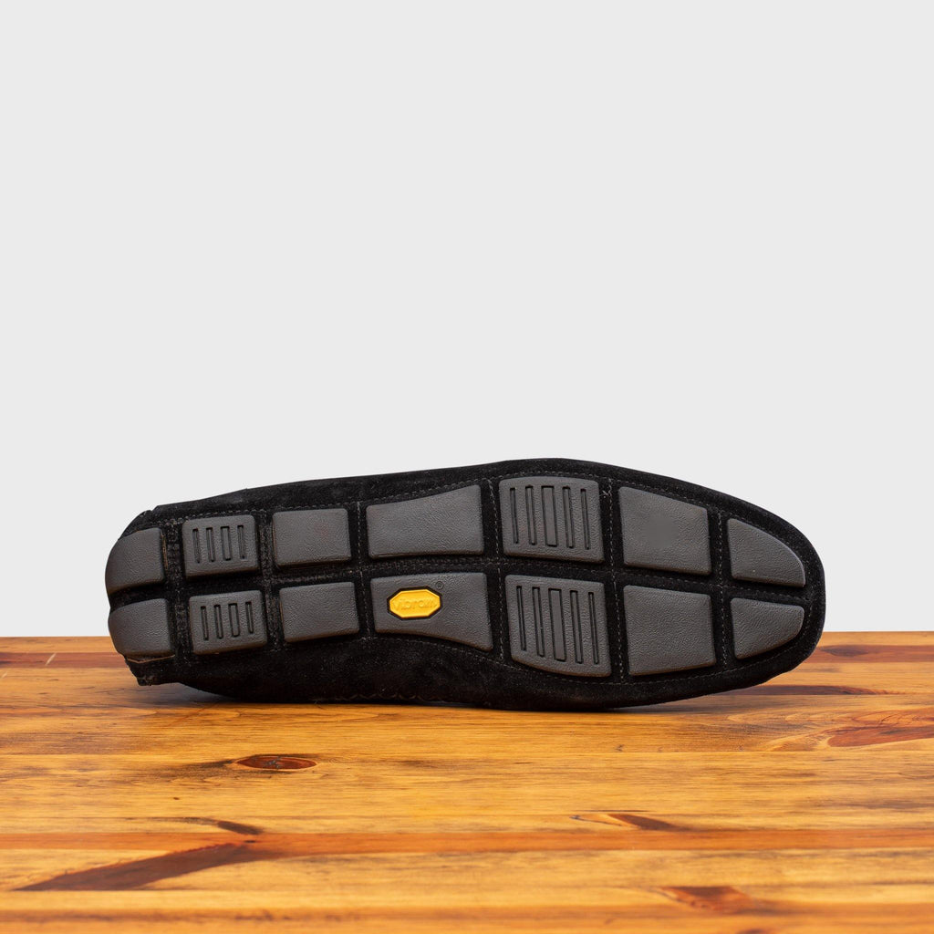 Full Rubber Vibram Outsole of 5303 Calzoleria Toscana Black Venetian Suede Driver on top of a wooden table