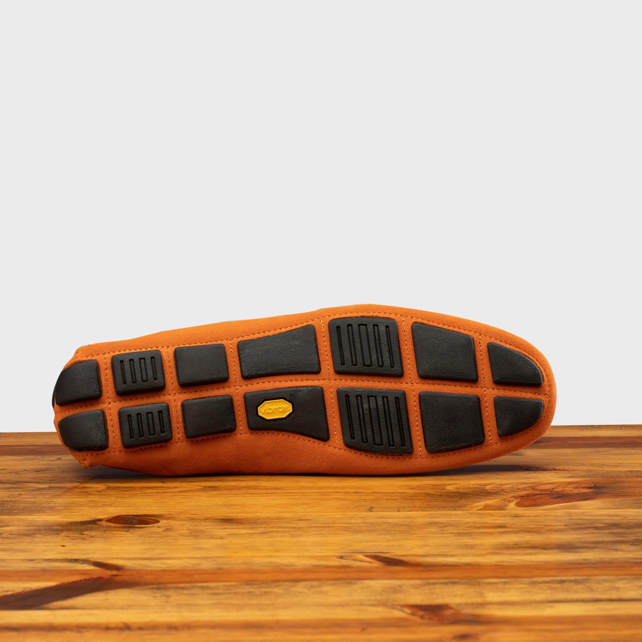 Full Rubber Vibram Outsole of 5303 Calzoleria Toscana Papaya Venetian Suede Driver on top of a wooden table