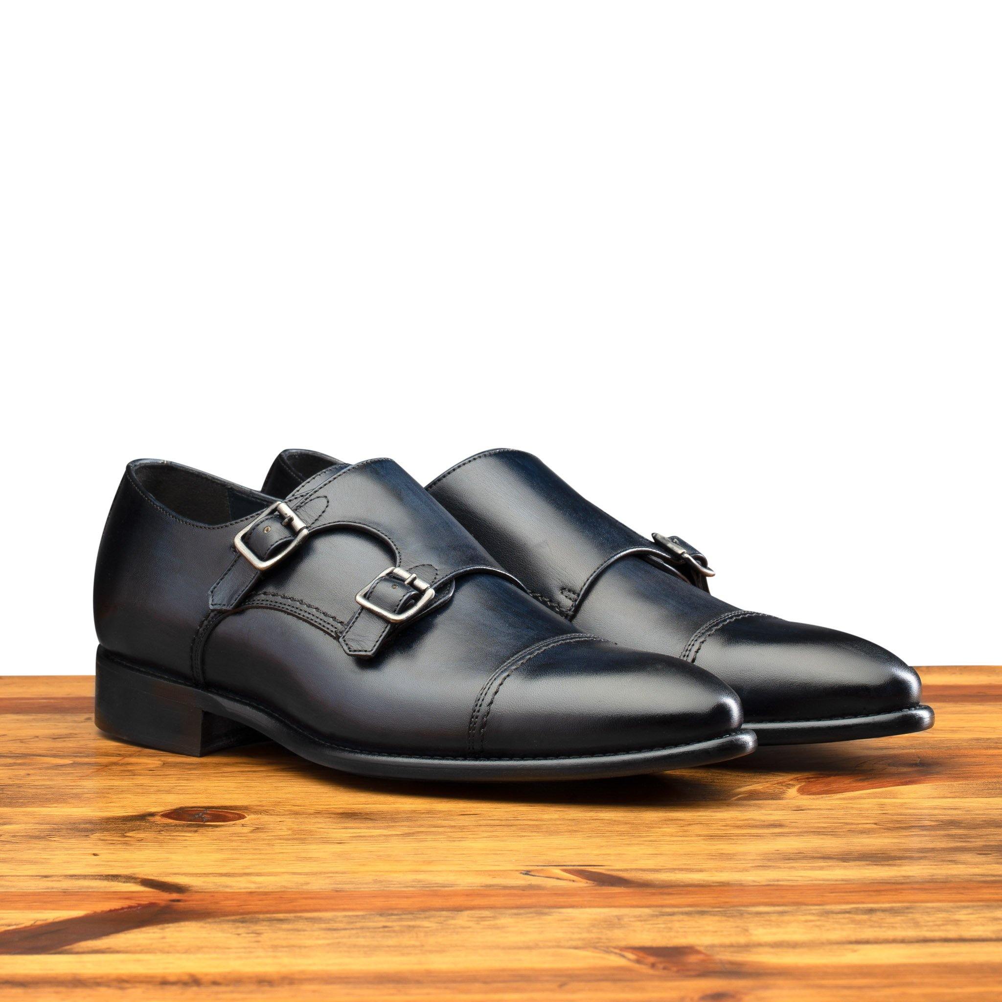 Pair of 6582 Calzoleria Toscana Blue Monkstrap Cap Toe on top of a wooden table