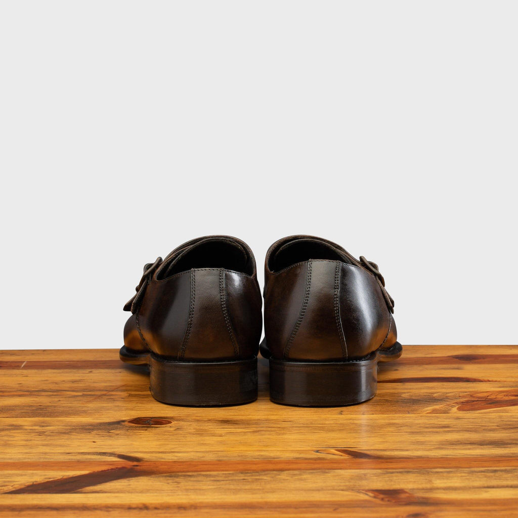 Back profile of 6582 Calzoleria Toscana Moor Monkstrap Cap Toe on top of a wooden table