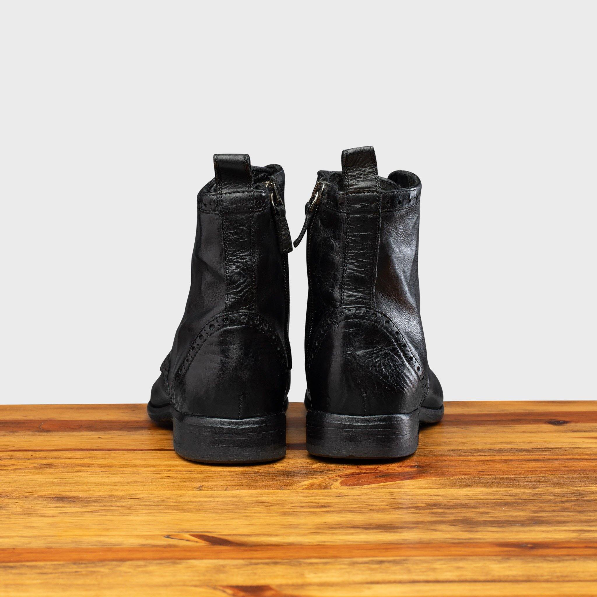 Back profile of 7149 Calzoleria Toscana Women's Black Dip-Dyed Diver Combat Boot on top of a wooden table
