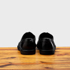 Back profile of 7839 Calzoleria Toscana Black Elba Slip-On on top of a wooden table