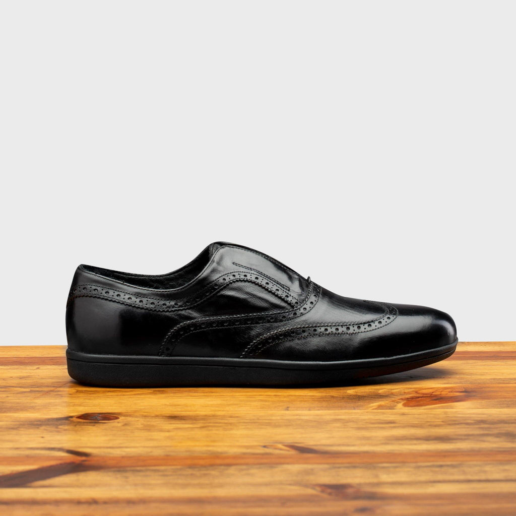 Side profile of 7839 Calzoleria Toscana Black Elba Slip-On on top of a wooden table