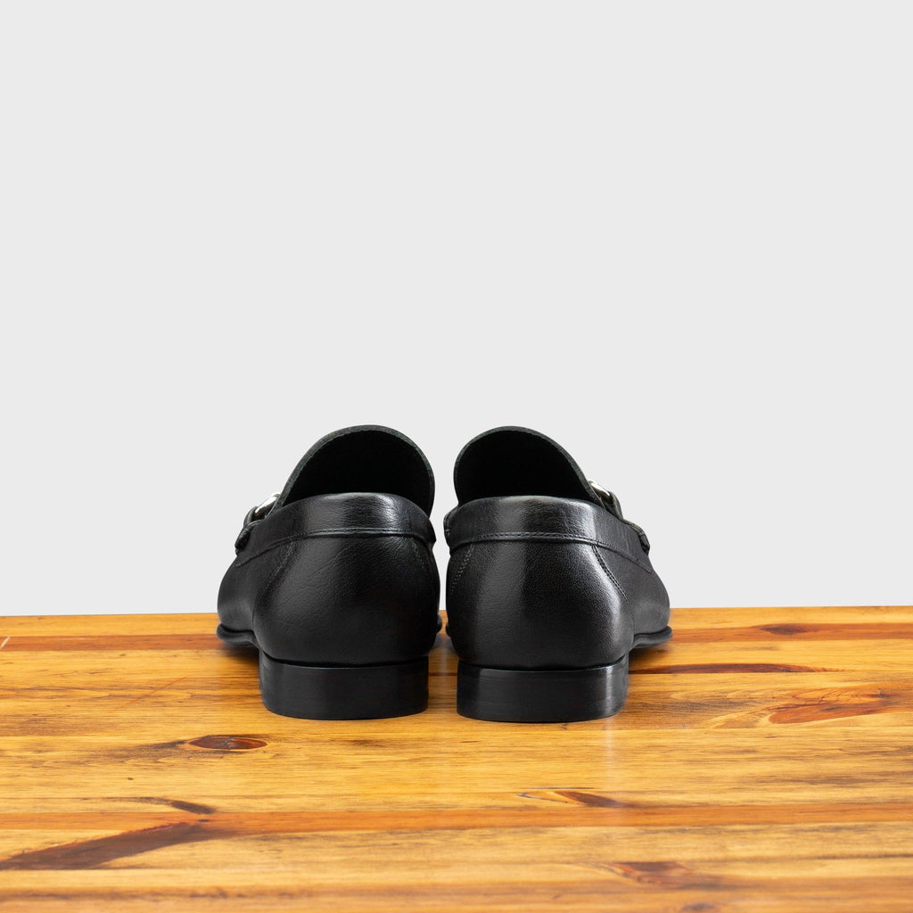 Back profile of 8616-M Calzoleria Toscana Black Buff Calf Slip-On on top of a wooden table