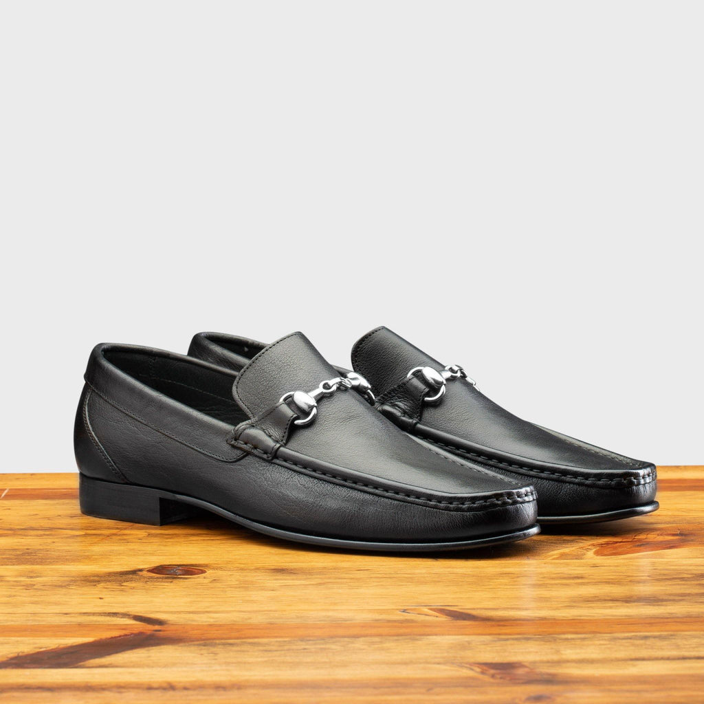 Pair of 8616-M Calzoleria Toscana Black Buff Calf Slip-On on top of a wooden table