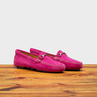 Pair of Fuchsia loafers on a wooden surface with a white background
