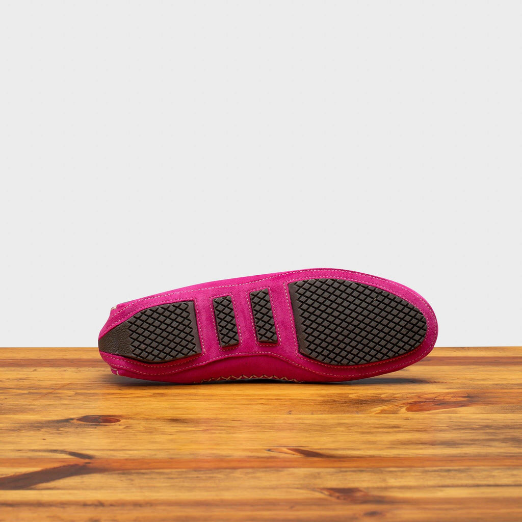 Rubber Outsole of 8976 Calzoleria Toscana Women's Fuschia Suede Driver on top of a wooden table