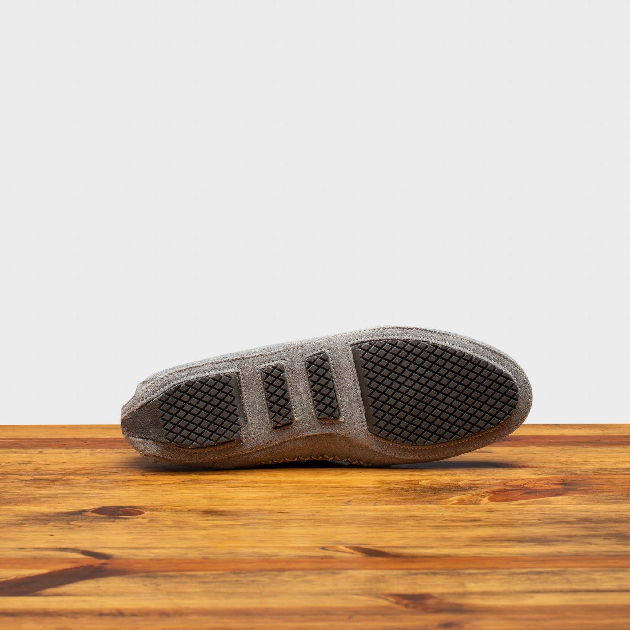 Rubber Outsole of 8976 Calzoleria Toscana Light Grey Suede Driver on top of a wooden table