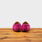 Back side of Fuchsia loafers on a wooden surface with a white background