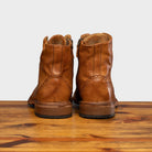 Pair of Brick leather boots on a wooden surface with a light gray background