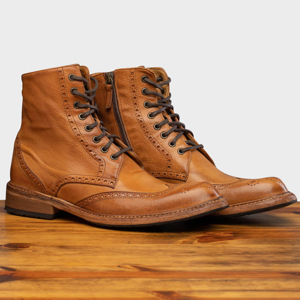 Pair of 9147 Calzoleria Toscana Brick Dip-Dyed Cesar Boot on top of a wooden table
