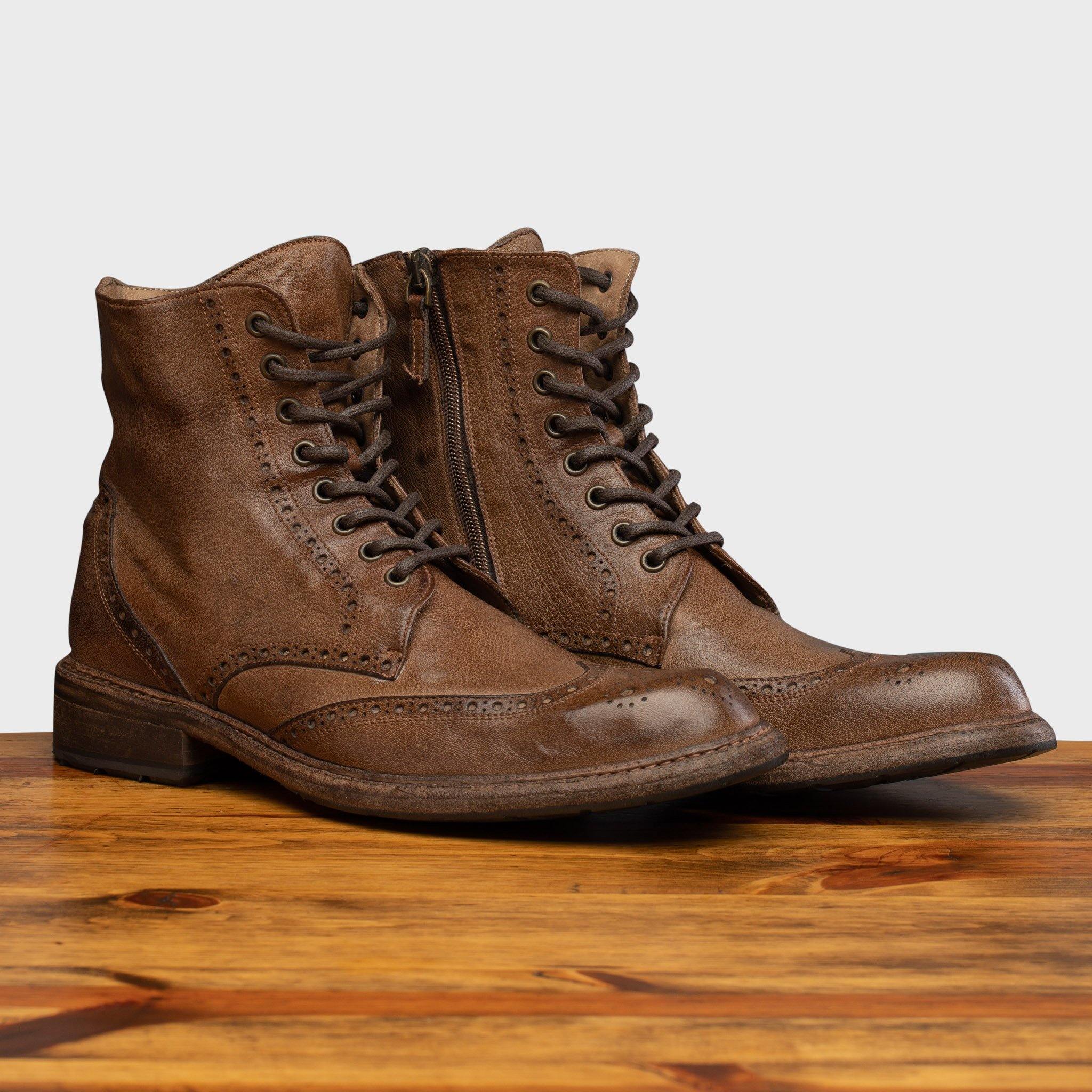 Pair of Moor leather boots on a wooden surface with a light gray background