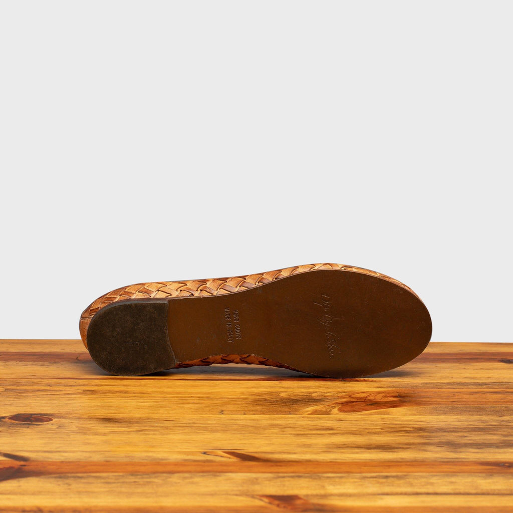Full leather outsole of B940 Calzoleria Toscana Brick Melania Ballerina on top of a wooden table