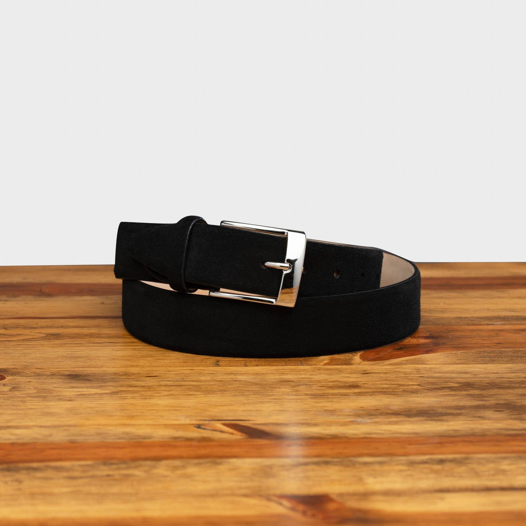 Front profile of C1359-S Calzoleria Toscana Black Velour Suede Belt curled around on top of a wooden table