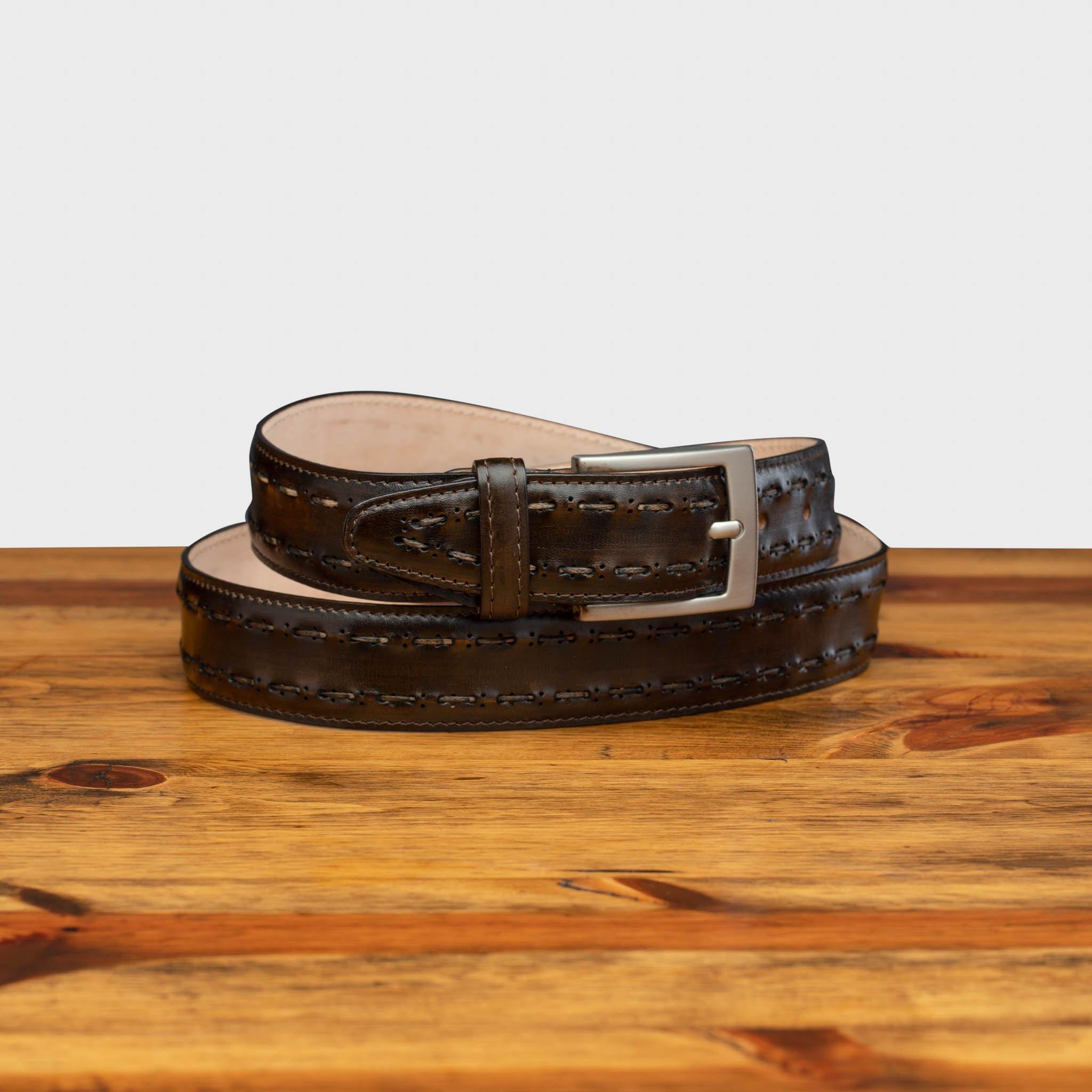 Full profile of C1482 Calzoleria Toscana Dark Brown Stitched Dress Belt curled up on top of a wooden table