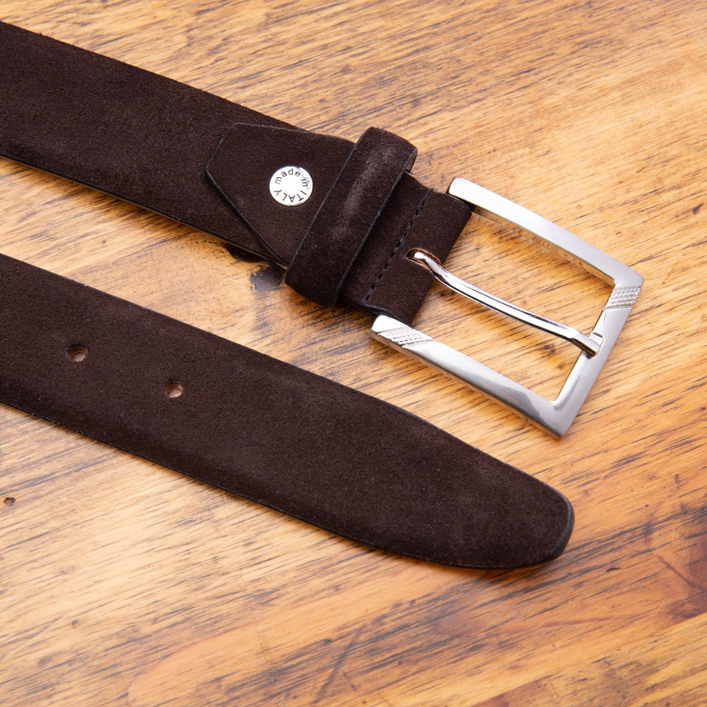 Up close picture of the silver buckle and velour suede details of C1499-S Calzoleria Toscana Chocolate Velour Suede Belt on top of a wooden table