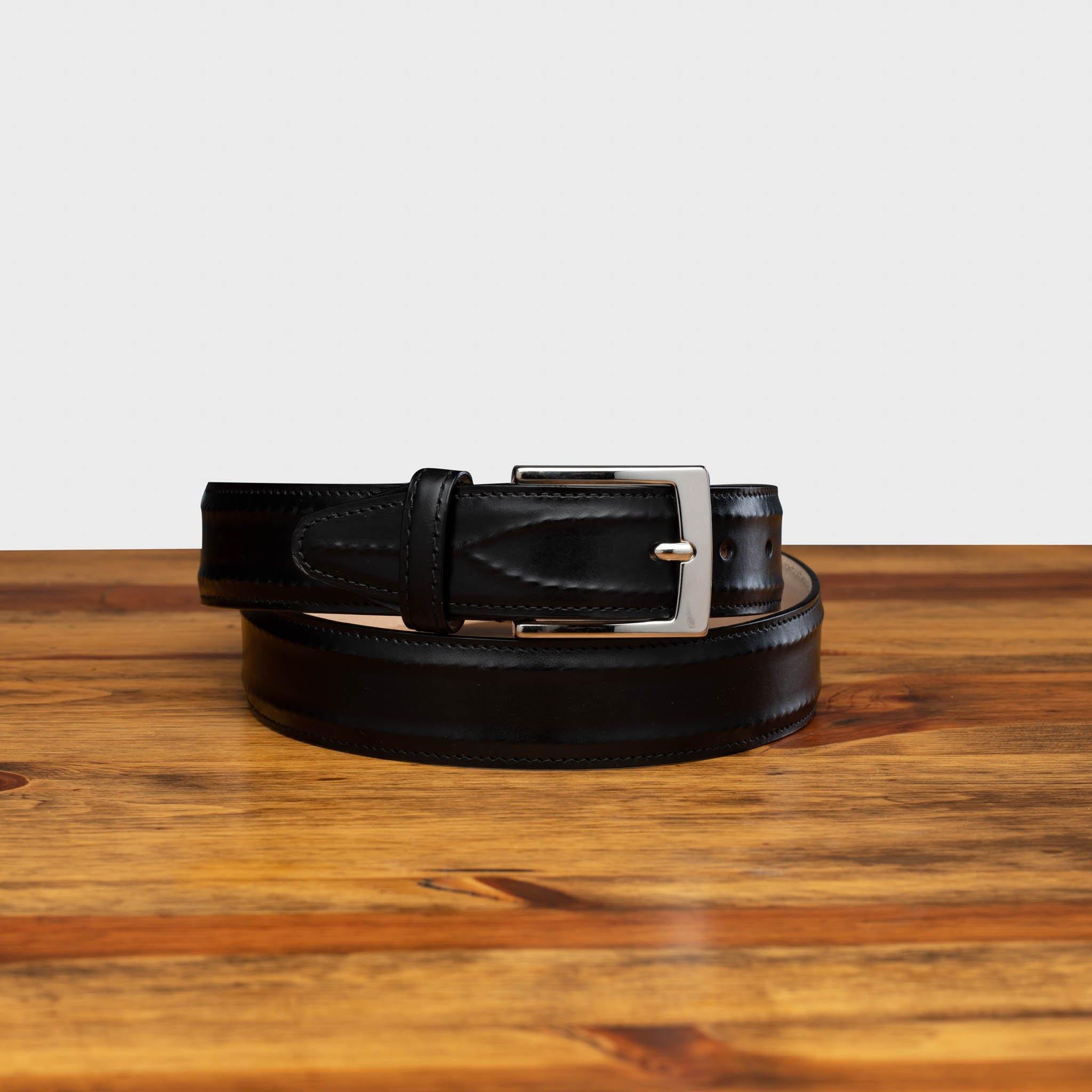 Front profile of C2216 Calzoleria Toscana Black Inner Stitched Dress Belt curled up on top of a wooden table