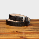 Front profile of C7981 Calzoleria Toscana Dark Brown Exotic Hornback Belt curled up on top of a wooden table