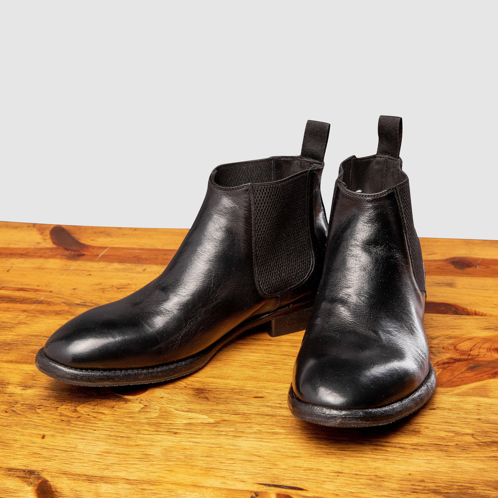 Pair of D367 Calzoleria Toscana Women's Black Chelsea Boot on top of a wooden table